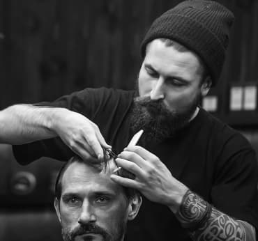 Barber does men`s haircut